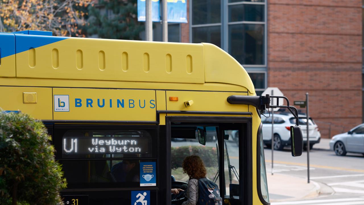 A student walks onto the Bruin Bus.