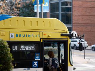 A student walks onto the Bruin Bus.